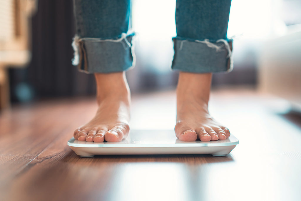 Woman stepping on scale